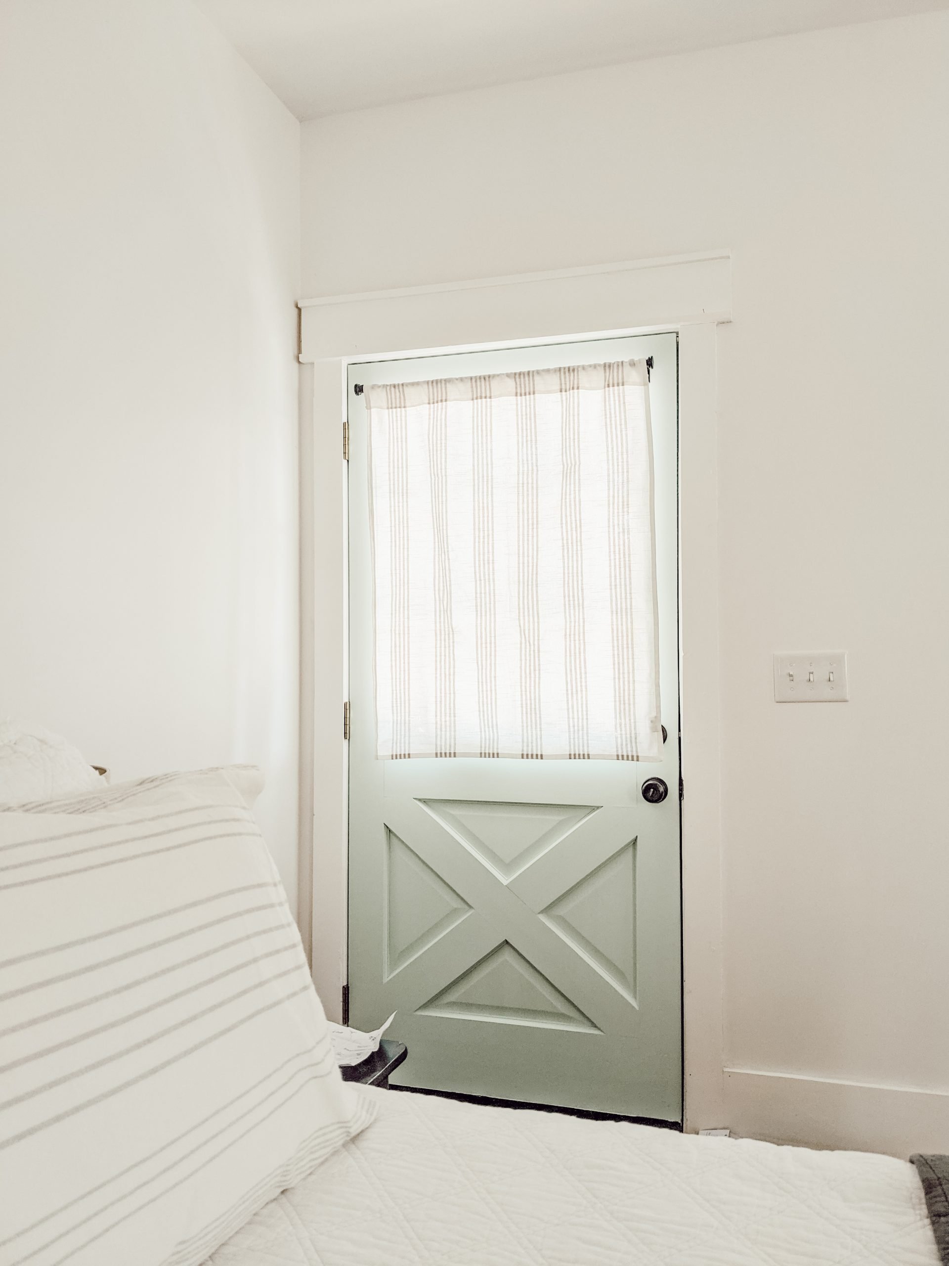 gray and white curtain on blue farmhouse door
