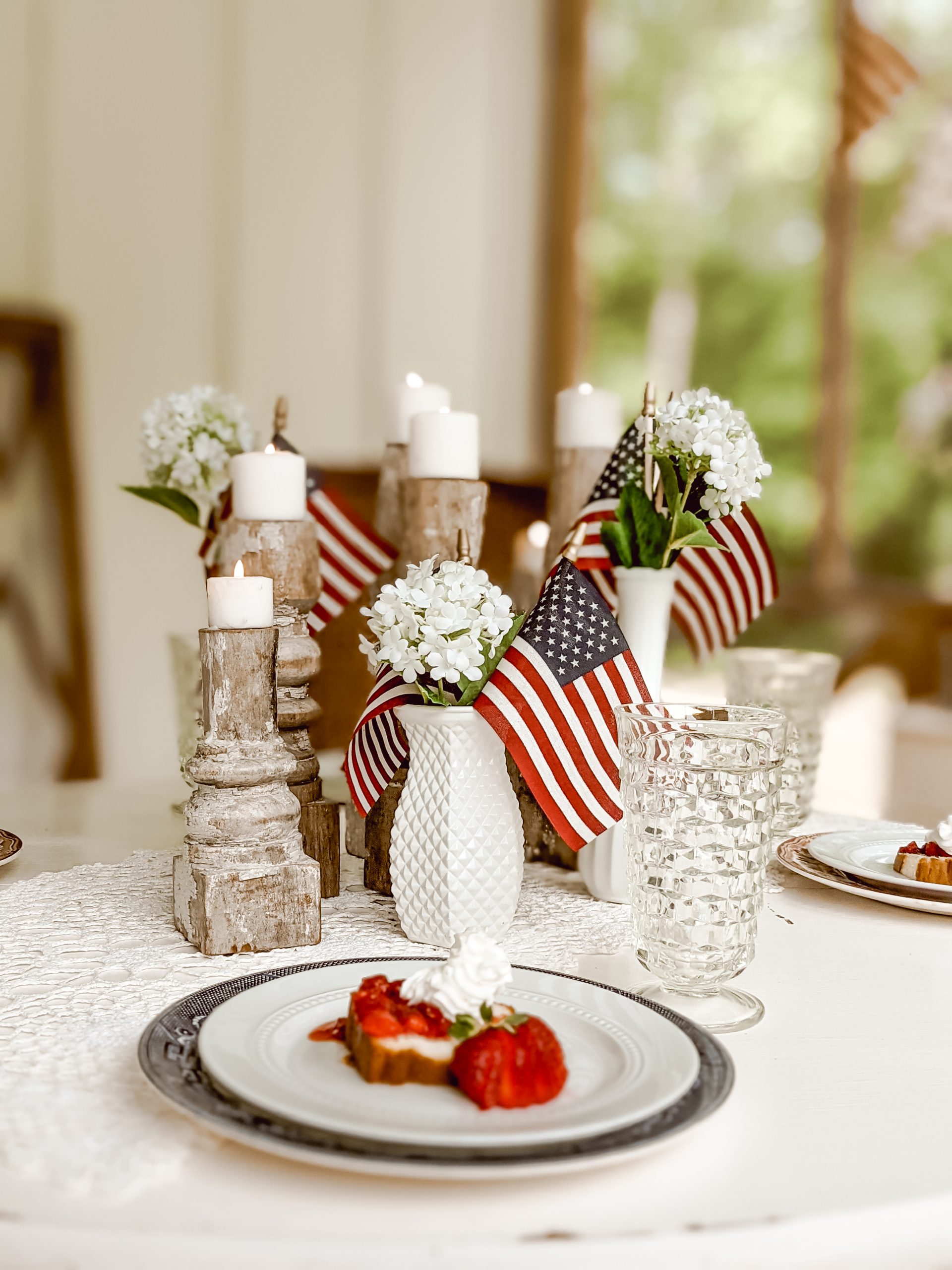 chippy white candlesticks, mini flags, and milk glass in red, white and blue centerpiece