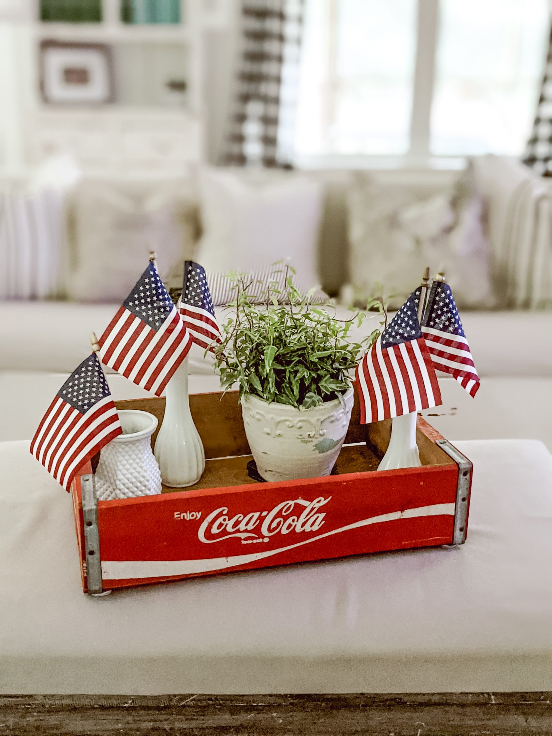 vintage coca cola crate with milk glass vases and mini flags
