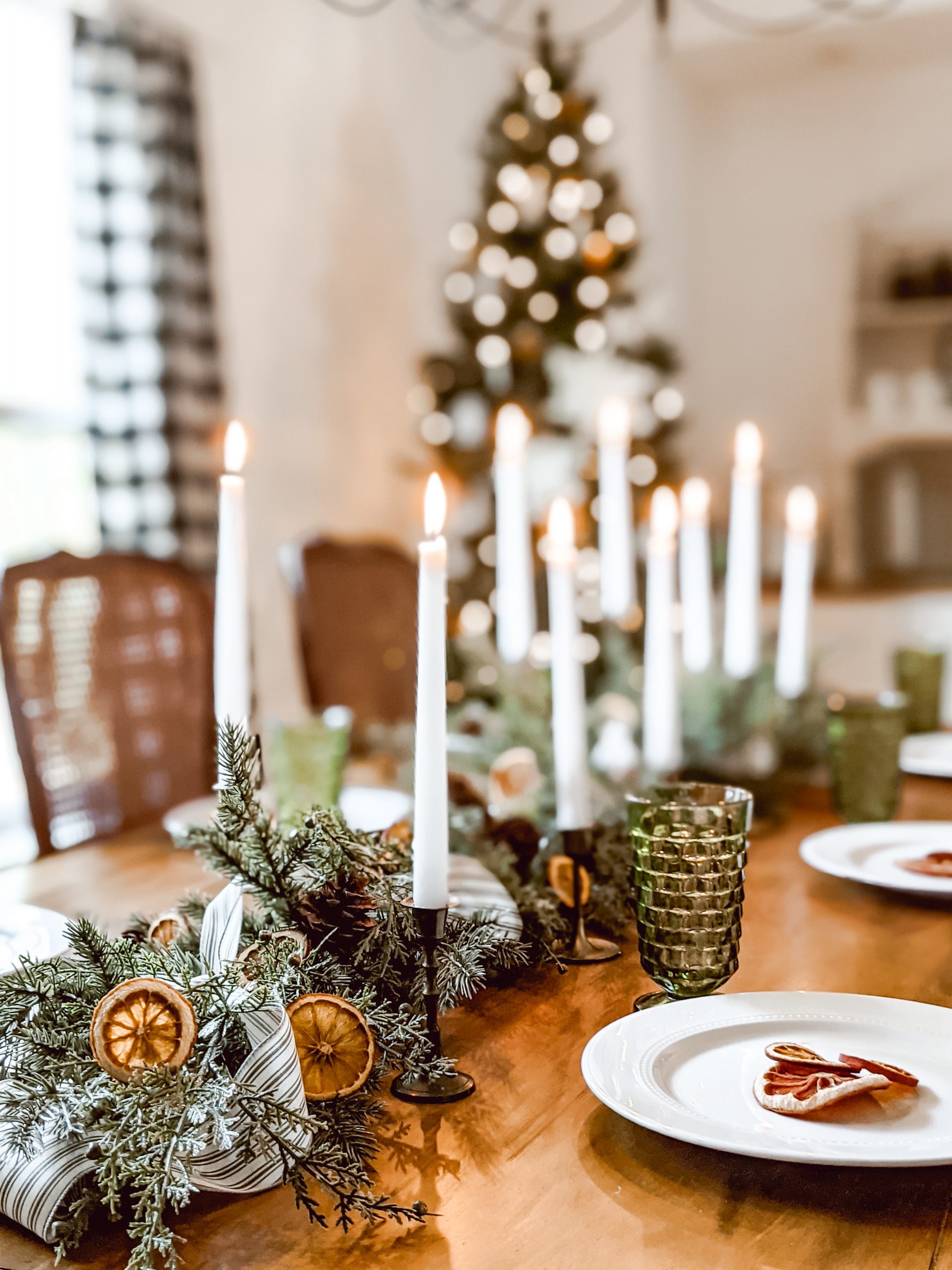 farmhouse Christmas tablescape with orange slices, ticking ribbon and brass candlesticks