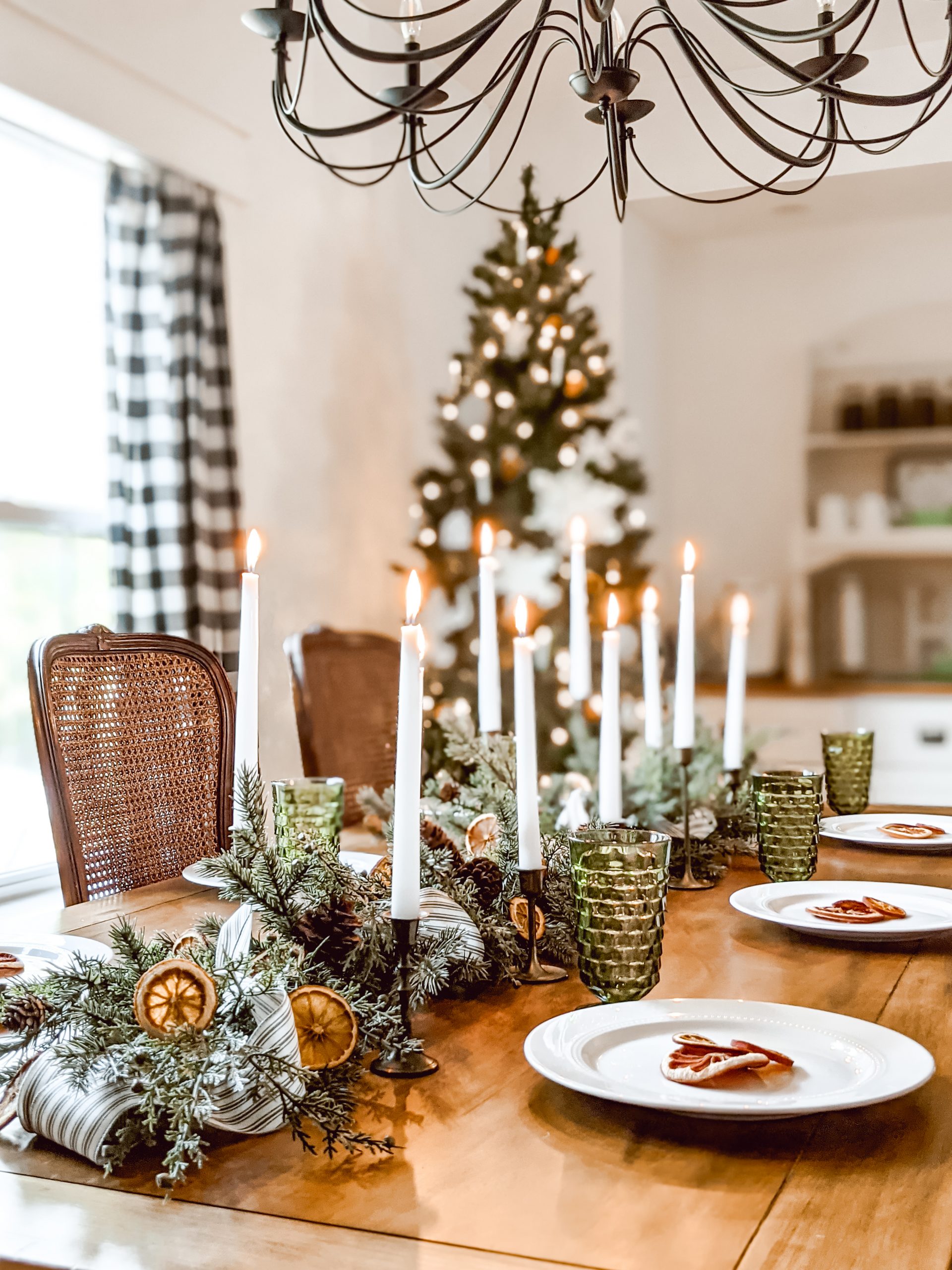 white taper candles and brass candlesticks on Christmas table