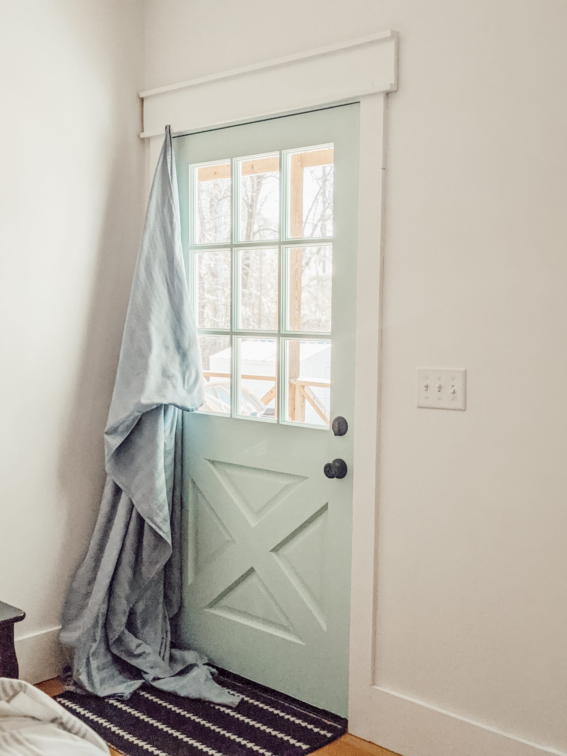 blue bedsheet over blue exterior door as temporary curtain