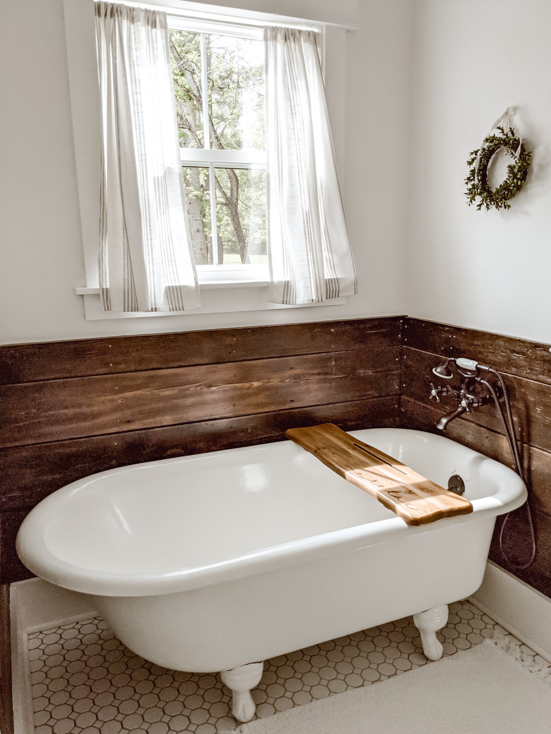 farm-cottage charm bathroom with clawfoot tub and reclaimed wood surround