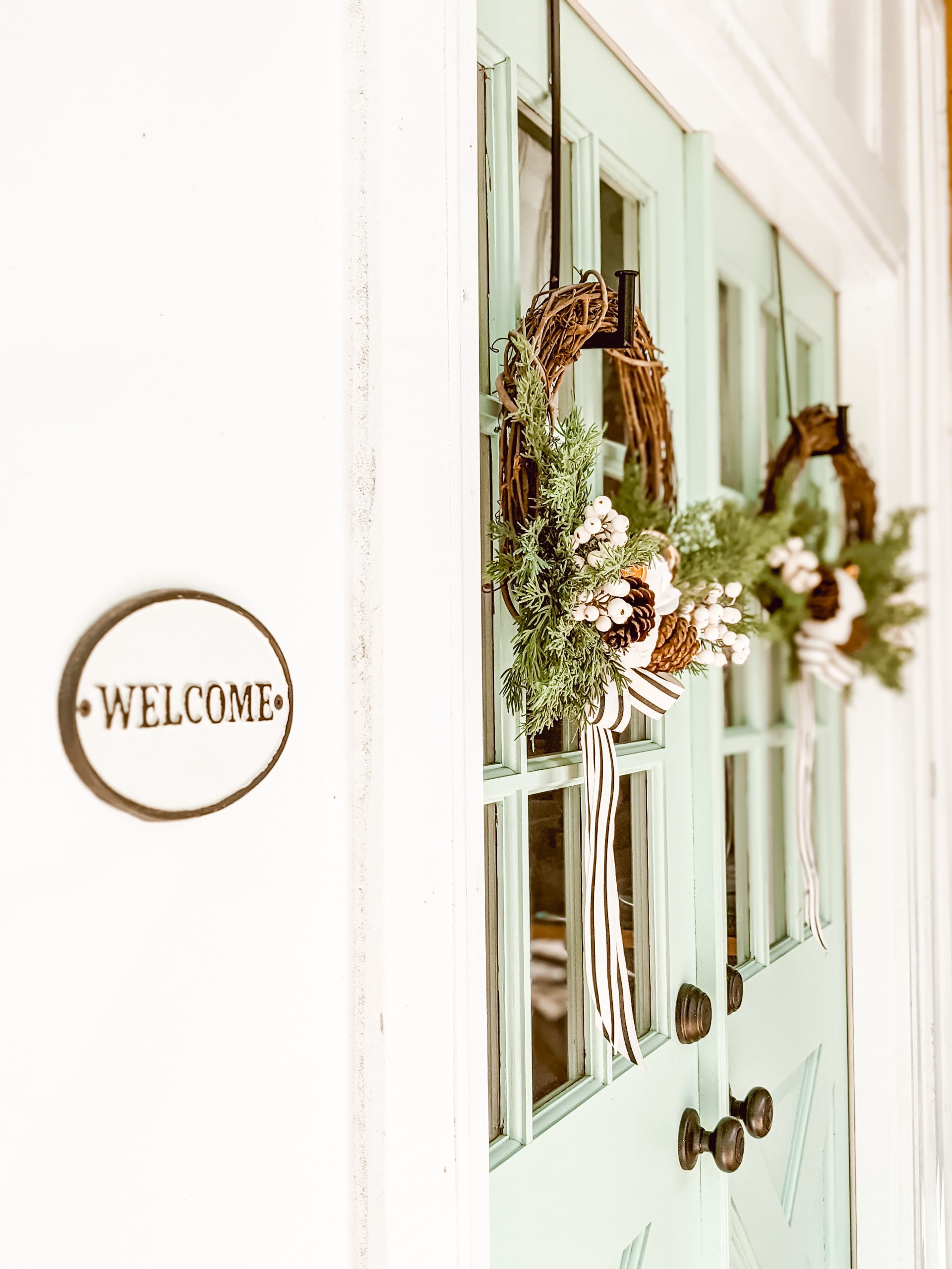 welcome sign and Christmas wreaths on double doors