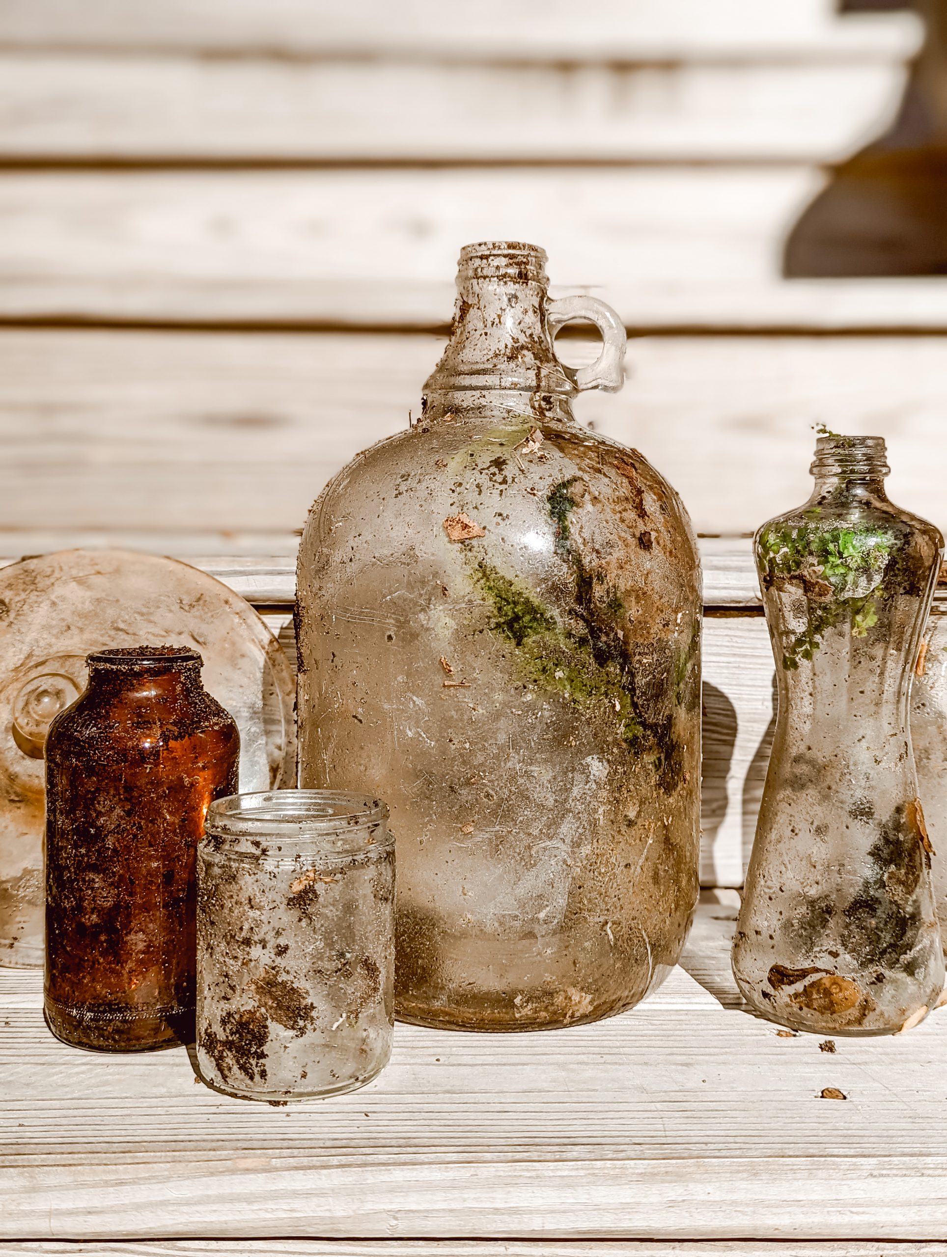 large growler and assorted vintage glass bottles