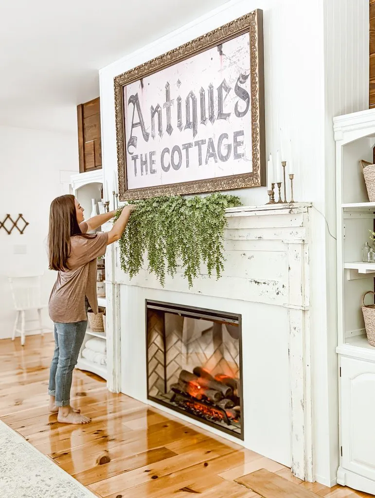 Brittany, home blogger from White & Woodgrain, adding decor to our new farmhouse cottage DIY fireplace