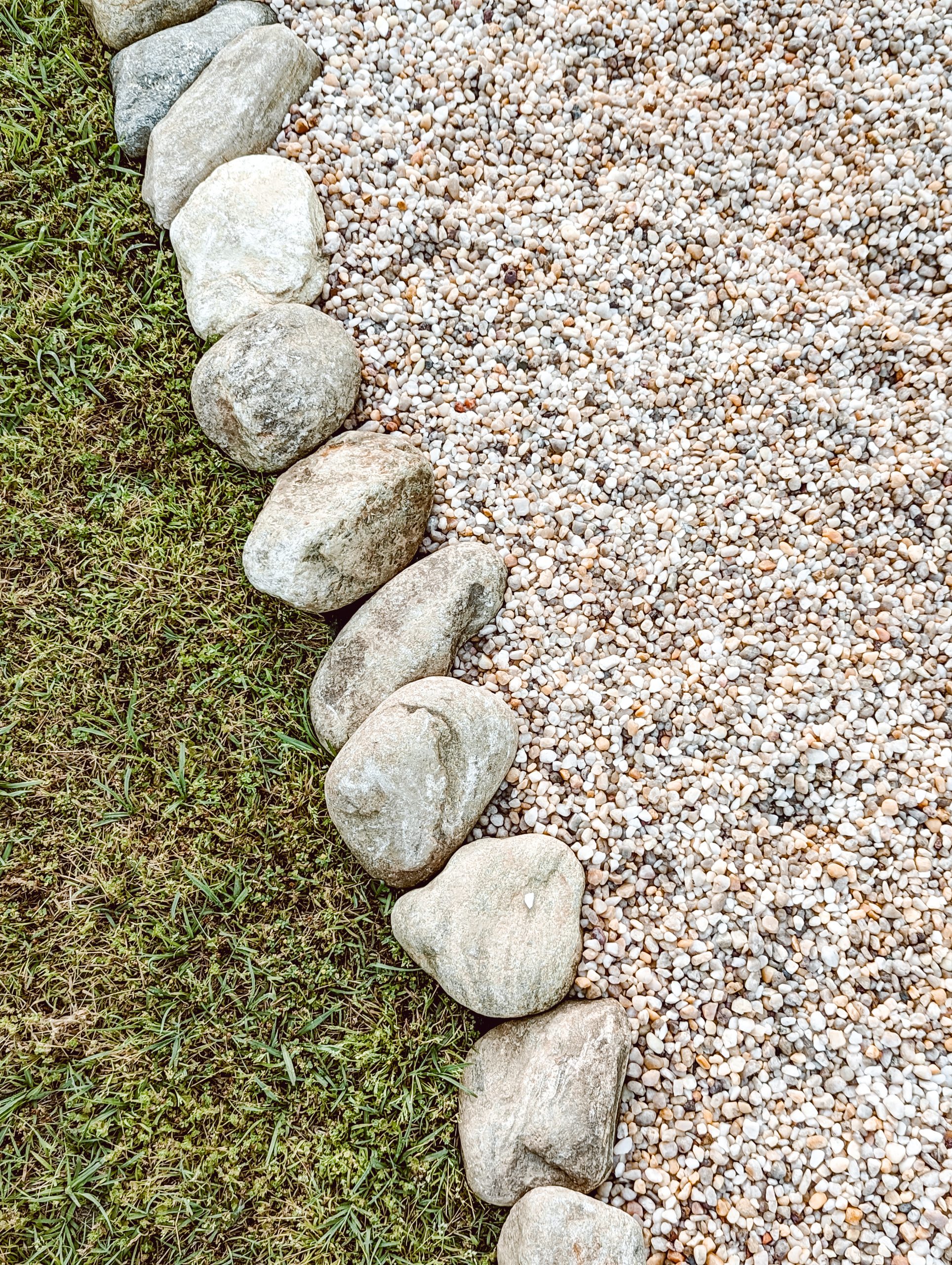 cane creek stones used as natural stone edging along the sides of a white pea gravel walkway