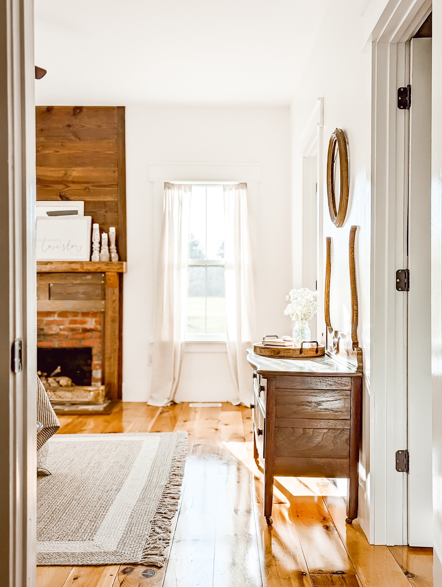 white farmhouse bedroom with pine floors and a reclaimed shiplap fireplace