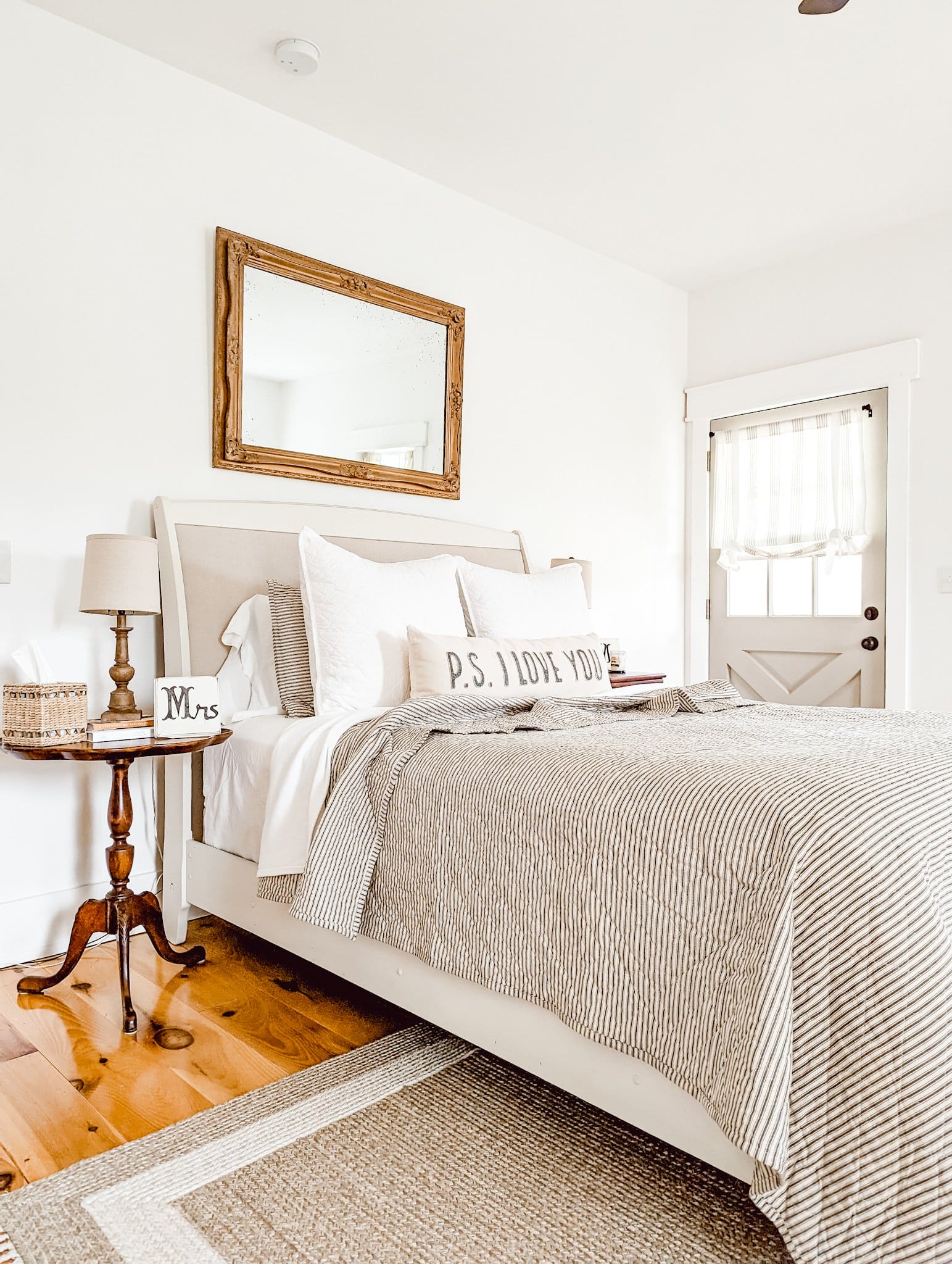 neutral white farmhouse cottage style bedroom with Bit of Sugar by Behr on the walls and wood floors