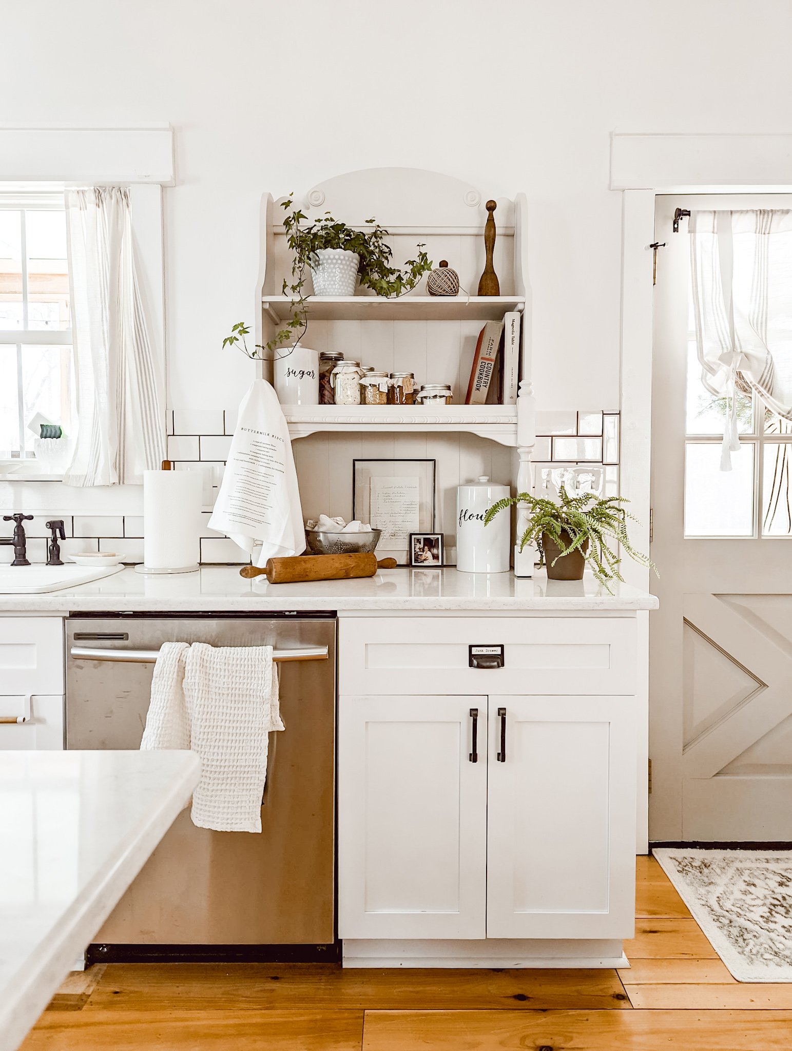 white cottage kitchen with shaker cabinets, white subway tile, and open shelves