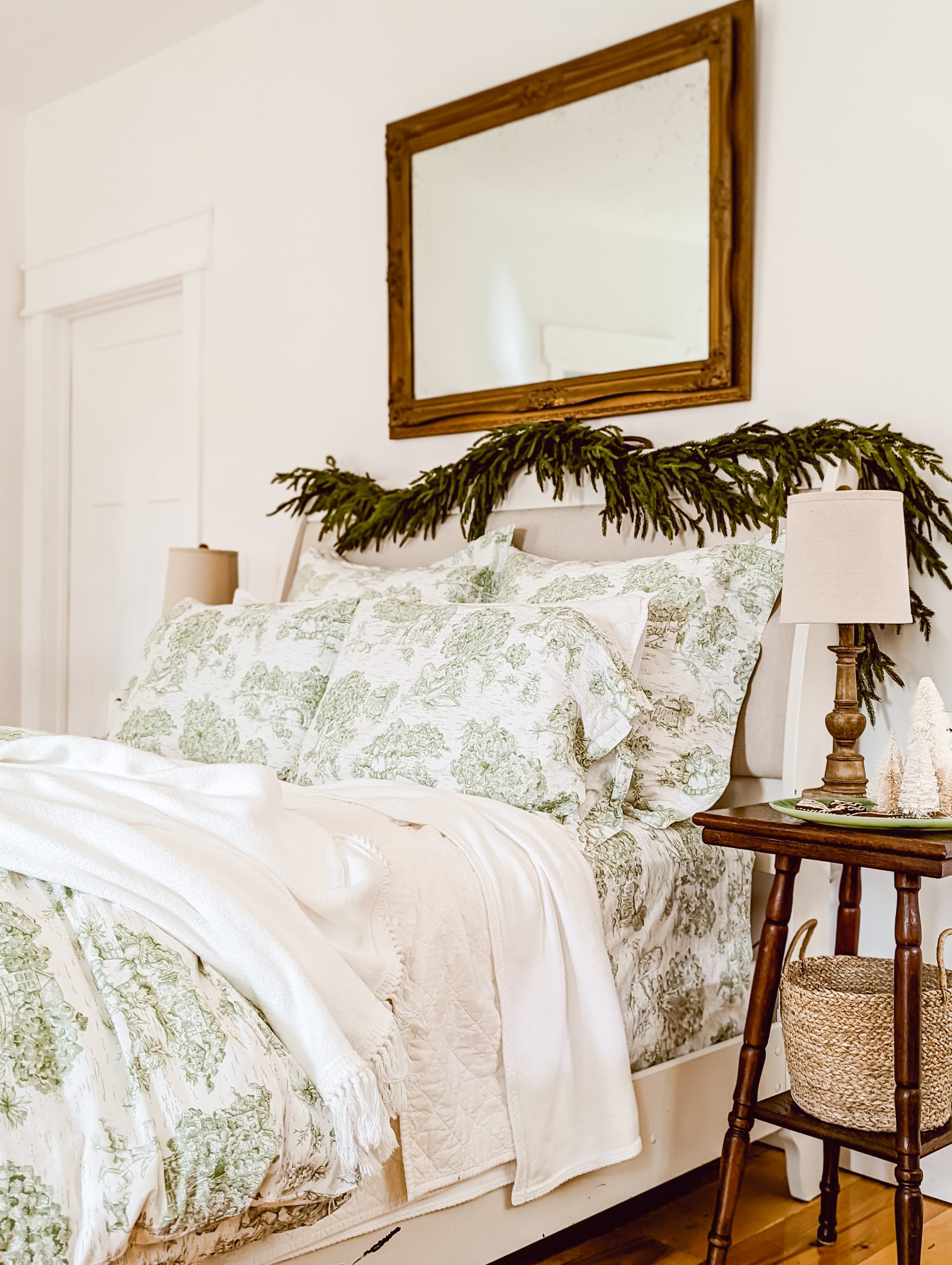layers of white bedding and green toile patterned bedding for a designer bedding look