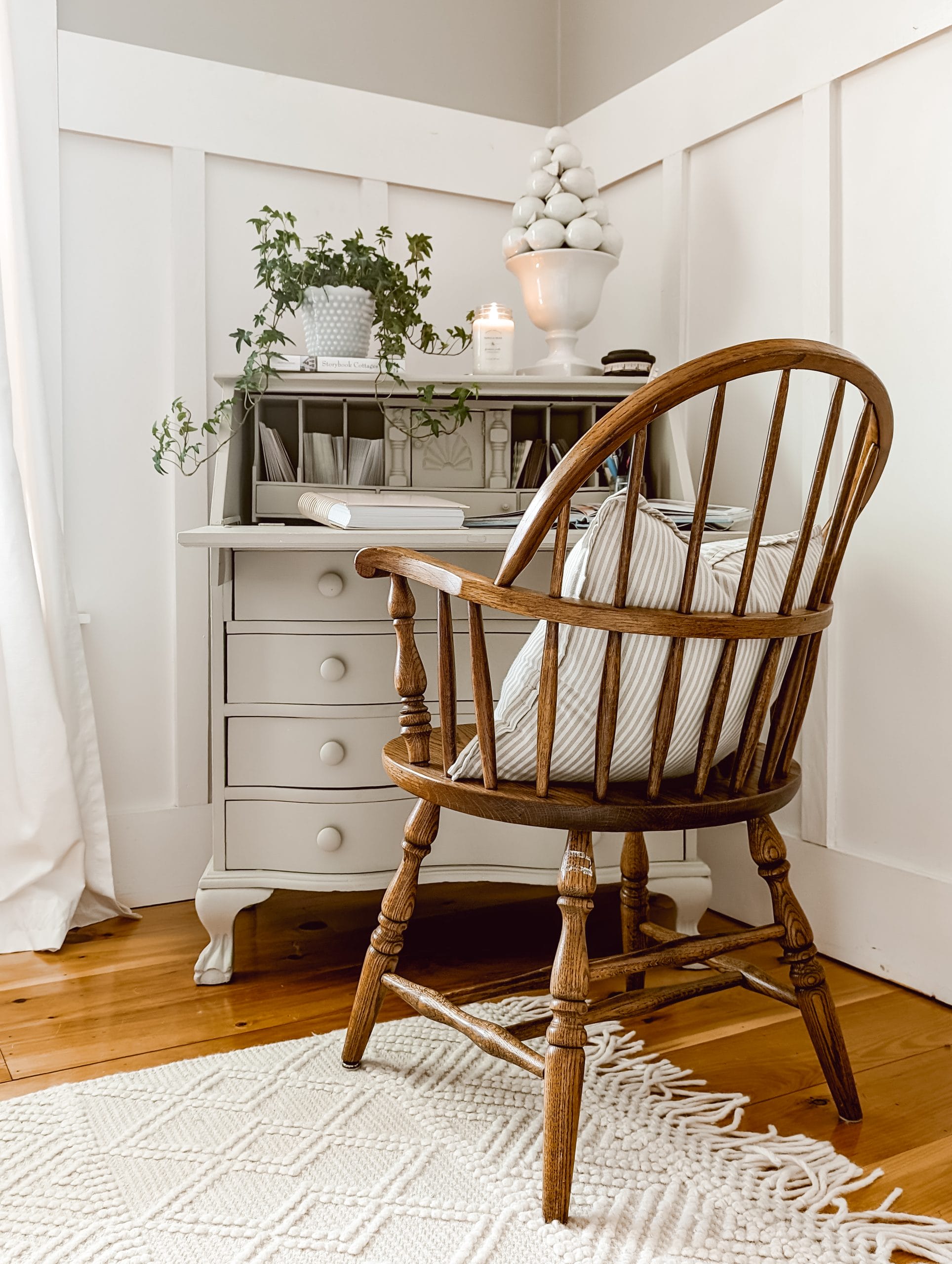 painted secretary desk and a wooden sitting chair in a cottage corner workspace